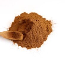 pile of powdered cinnamon with wooden spoon