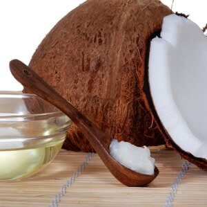a coconut and coconut oil on a spoon, cook with coconut oil, coconut oil good