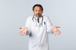 Confused doctor with hands outstretched