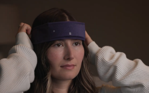 woman puts on SpatialSleep headband for defeating insomnia