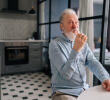 An older man taking a pill