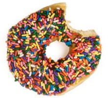 A bitten donut with chocolate icing and rainbow sprinkles
