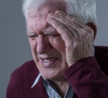 Elderly upset man with terrible cluster headache