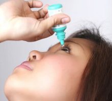 a young woman putting in eye drops, dry eye disase