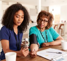 nurse using sphygmomanometer in home blood pressure measurement to determine if patient needs blood pressure medication to reduce blood pressure