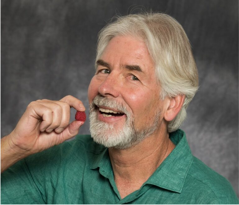 Christopher Gardner, PhD, is a nutrition researcher eating a raspberry