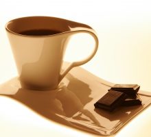 Cup of black coffee and two squares of dark chocolate on a tray