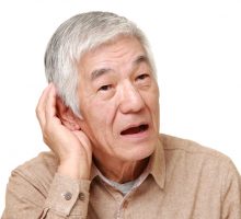 portrait of Hearing impaired senior Japanese man cupping his ear