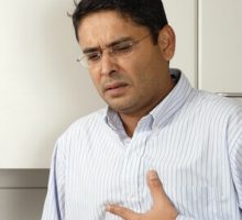 man with heartburn or stomach upset holding his chest
