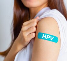 Young woman displays bandage for HPV vaccine