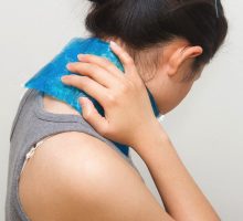 woman putting cold gel pack on neck