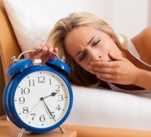 sleepy woman with alarm clock