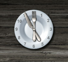 Plate with clock face numbers, fork and knife to designate restricting eating time