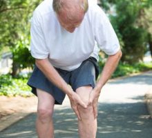 a man with arthritic knees, holding his knee in pain