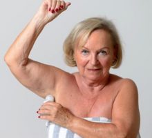 Senior lady applying roll on deodorant