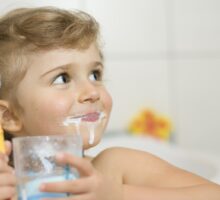 Little girl brushing teeth and getting ready to rinse