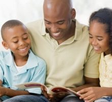 Man reading stories to two children