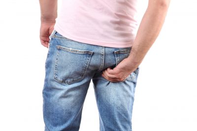 man scratching itchy bottom