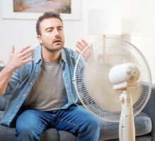 man sweating in front of fan