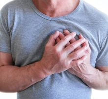 Man clutching his chest because of heart pain