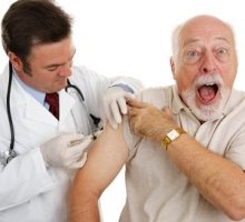 Senior man at the doctor's office, surprised by a painful flu shot injection