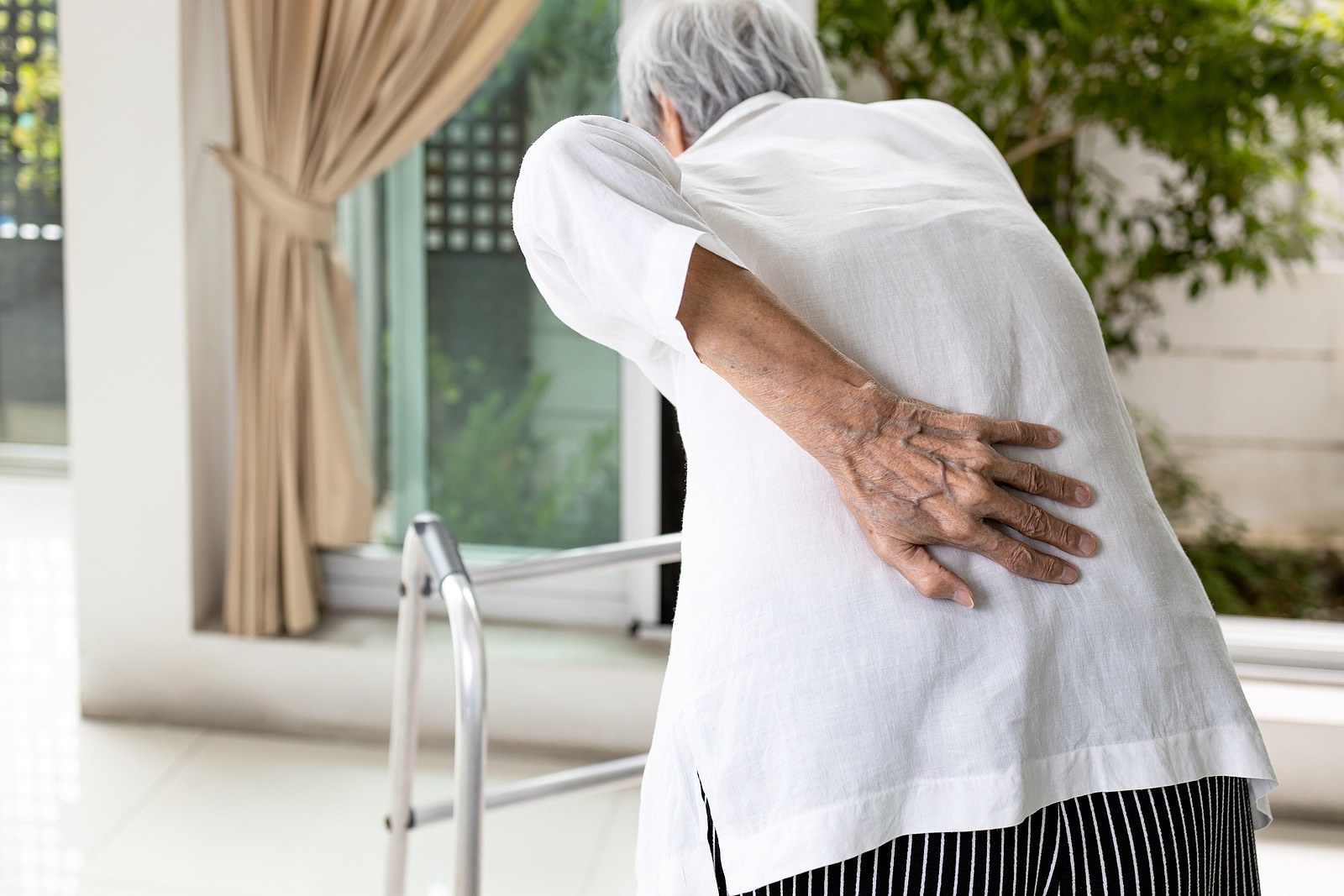 Prolia For Osteoporosis Can Cause Low Calcium And Rebound Fractures   Old Woman Back Pain Walker 