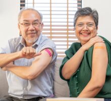 Older people showing off bandages on arms after vaccination