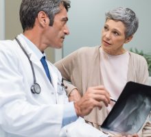 Male doctor and senior female patient discussing osteoporosis drug options