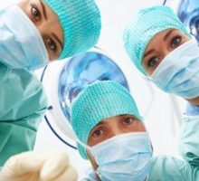 close up of three doctors faces wearing surgical scrubs and masks