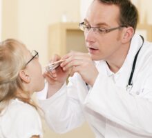 pediatrician examines a child with a sore throat who may have strep infection