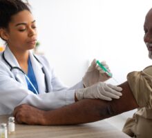 Older person receiving shingles vaccination in left arm. It may protect the brain from dementia as well.