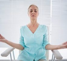 Senior woman doing chair yoga