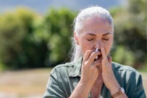 woman using nasal spray for year-round allergies