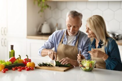 Sexy older couple cooking healthy Mediterranean Diet food.