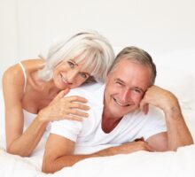 sexy senior couple relaxing and smiling on bed