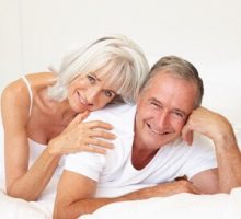 Senior Couple Relaxing On Bed