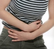 person holding their stomach in pain from stomach ache or IBS