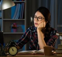 sleep-deprived young woman is studying late