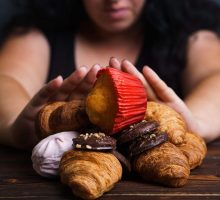 a woman pushing away sweets and pastries