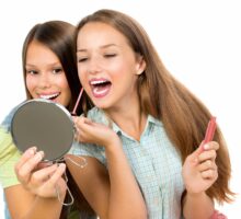 Teenage girls applying makeup and cosmetics