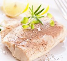 a cooked trout fillet with fresh herbs and lemon