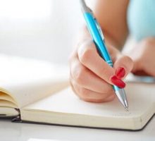 young woman writing a gratitude journal
