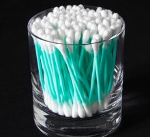 Turquoise cotton swabs in clear glass jar