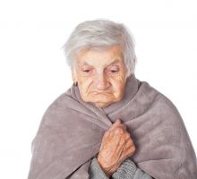 elderly woman wrapped in gray blanket due to respiratory infection, dementia genes