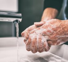 man washing hands in sink leading to dry skin and cracks