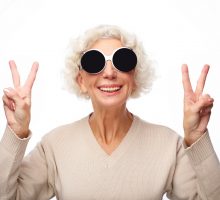 older woman wearing big sunglasses with curly white hair
