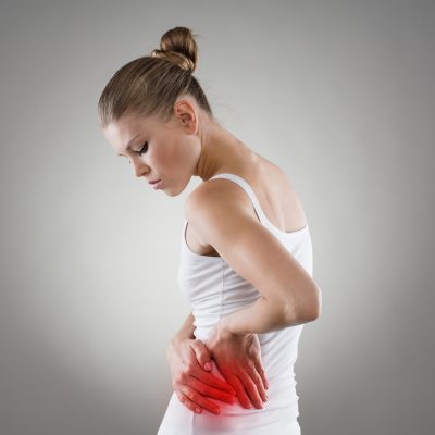Woman experiencing painful kidney stones holds her side