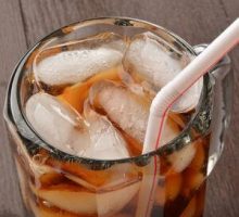 Close up of a soda in a mug with a straw; example of ultra-processed food