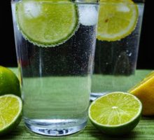 Glass with cold sparkling water lime and lemon