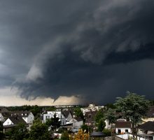 a thunderstorm with dark clouds looming over a town